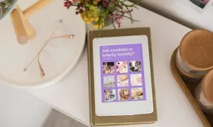 E-book "Jak zarabiać w branży beauty?" na tablecie. Obok okulary i bukiet kwiatów. Idealne inspiracje dla każdej stylistki.
