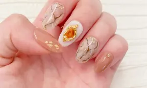 Eleganckie paznokcie z efektem marmuru i złotymi płatkami. Żel kamuflujący jak używać? Ten manicure pokazuje, jak pięknie można go połączyć z innymi zdobieniami.