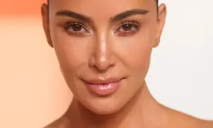 Zbliżenie na twarz Kim Kardashian z podkreślonymi rzęsami i błyszczącymi ustami.