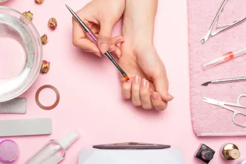 Narzędzia do manicure i dłonie przygotowujące się do zabiegu. Dowiedz się, jak odkleić tipsy i uzyskać idealne paznokcie.