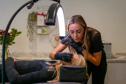 Stylistka wykonuje laminację rzęs. Zabieg jest bezpieczny dla osób od 16 roku życia.