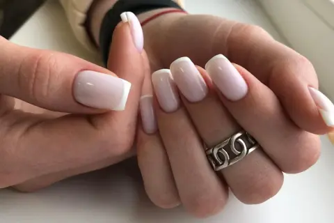 Eleganckie paznokcie ślubne kwadratowe w stylu francuskim, z delikatnym różowym lakierem i białymi końcówkami. Idealne na ten wyjątkowy dzień.