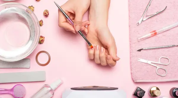 Narzędzia do manicure i dłonie przygotowujące się do zabiegu. Dowiedz się, jak odkleić tipsy i uzyskać idealne paznokcie.