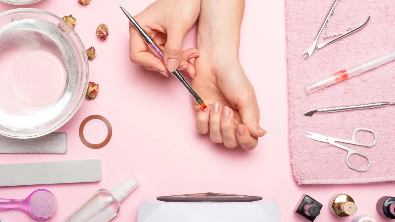 Narzędzia do manicure i dłonie przygotowujące się do zabiegu. Dowiedz się, jak odkleić tipsy i uzyskać idealne paznokcie.